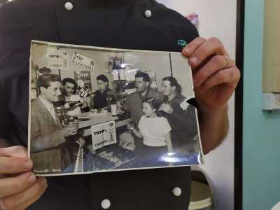 Il proprietario ci mostra una vecchia foto del bar, scattata in occasione di un grosso premio vinto grazie a una schedina fortunata